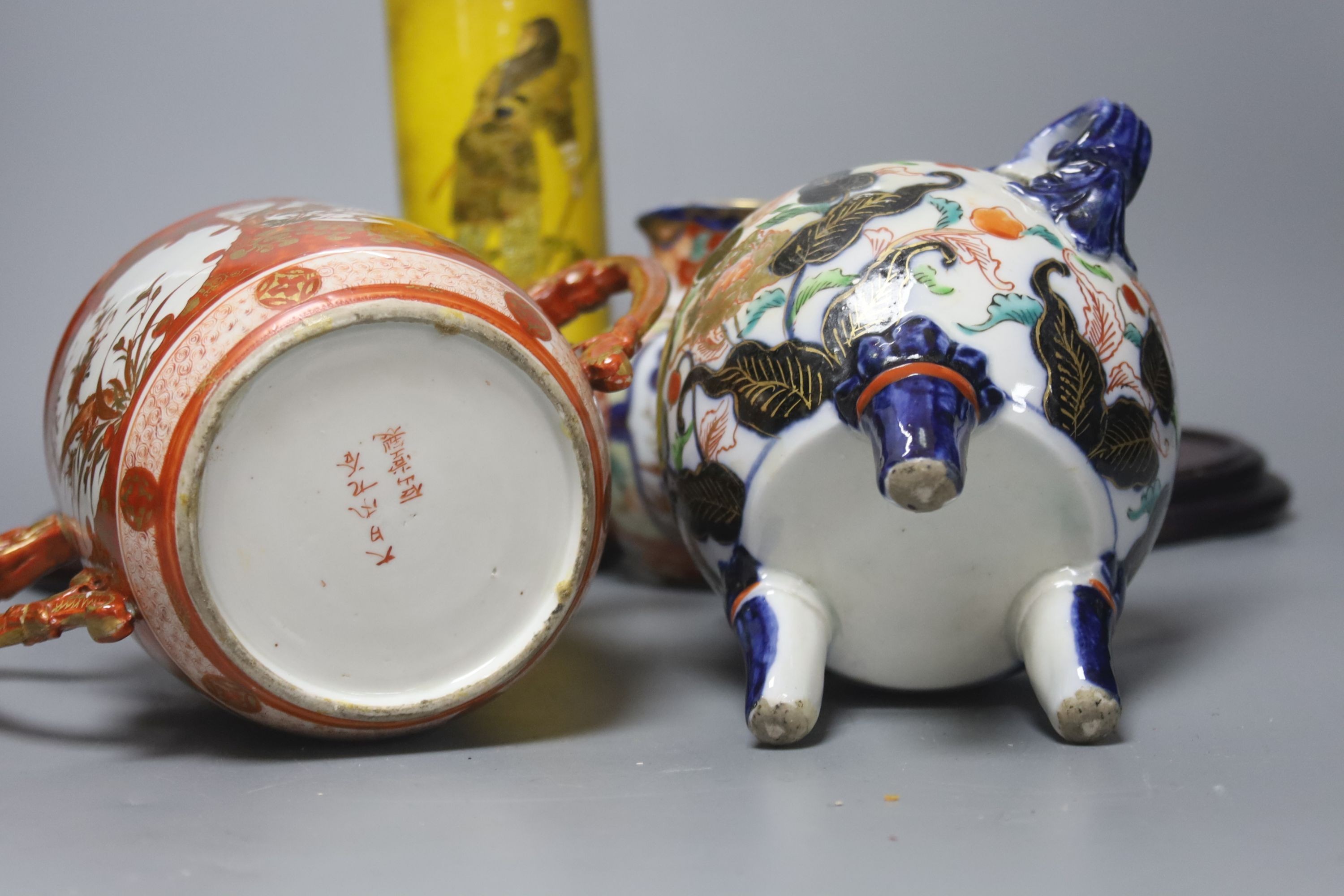A Satsuma yellow ground vase, a Kutani twin handled cup and cover, a Fukugawa Imari jug and an Imari koro and cover 27cm, three wood stands